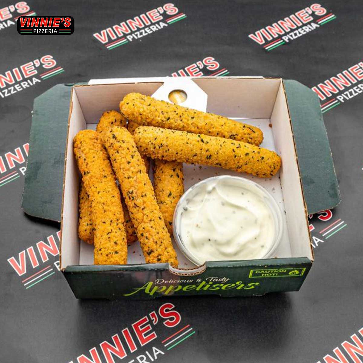 A takeaway box from Vinnie's Pizzeria’s mozzarella sticks and a small tub of dipping sauce.